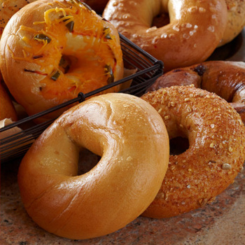 assortment of bagels on a surface and in a black wire basket