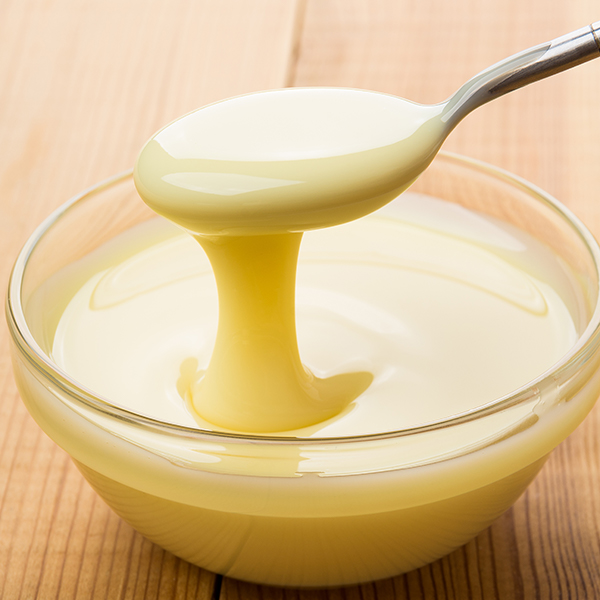 A bowl of sweet condensed milk with a spoon