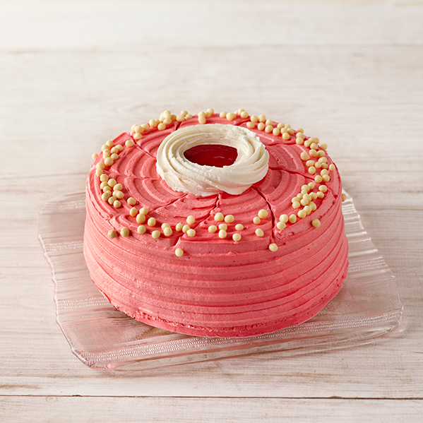 Frosted and decorated cherry cake on cutting board