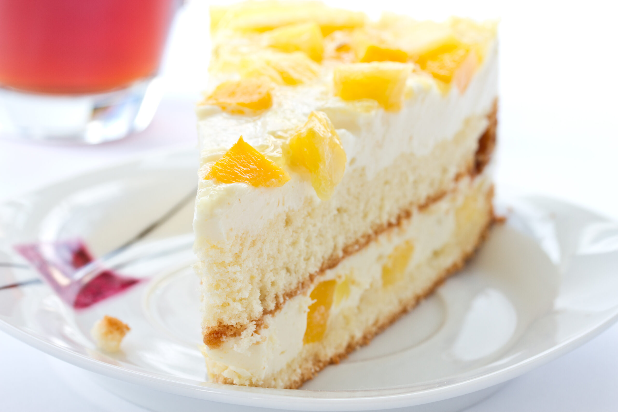 slice of pineapple cake with pineapple chunks and frosting on a white plate