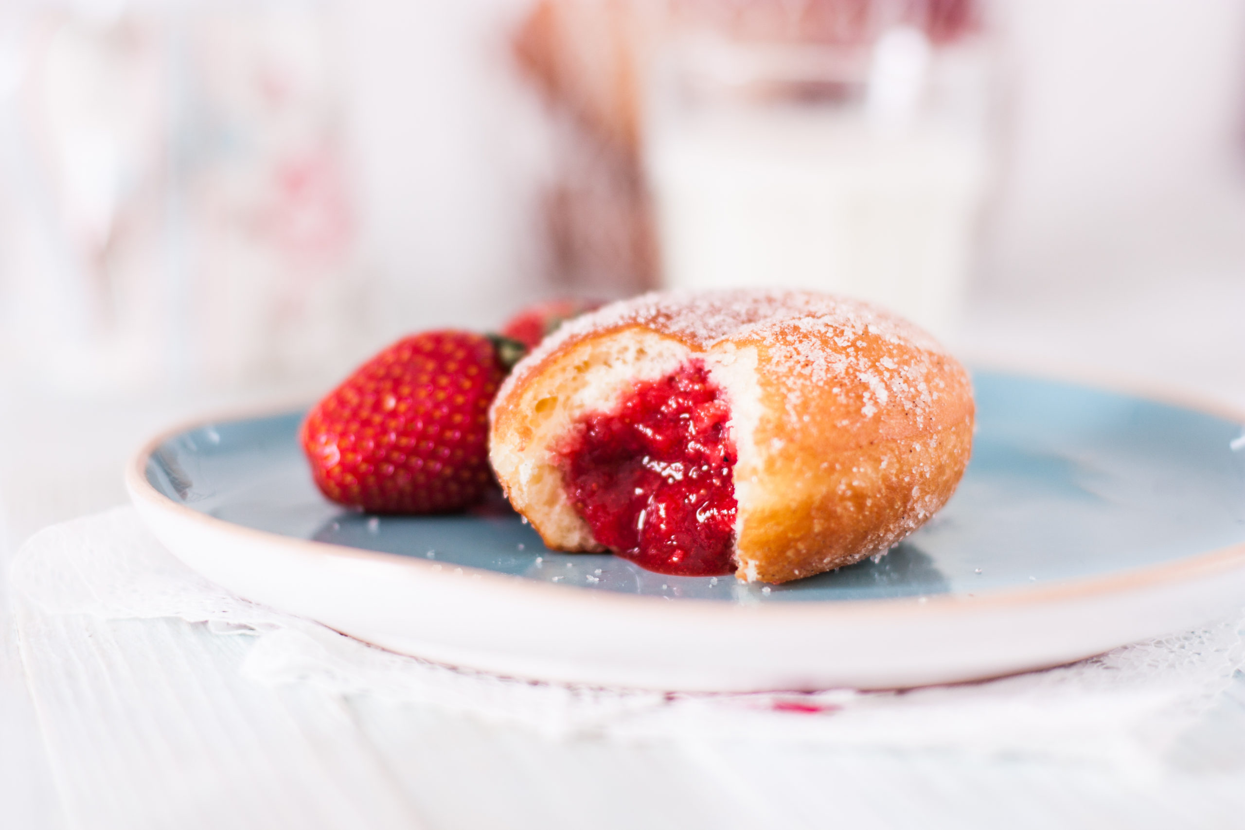 A donut cut open to show berry filling inside