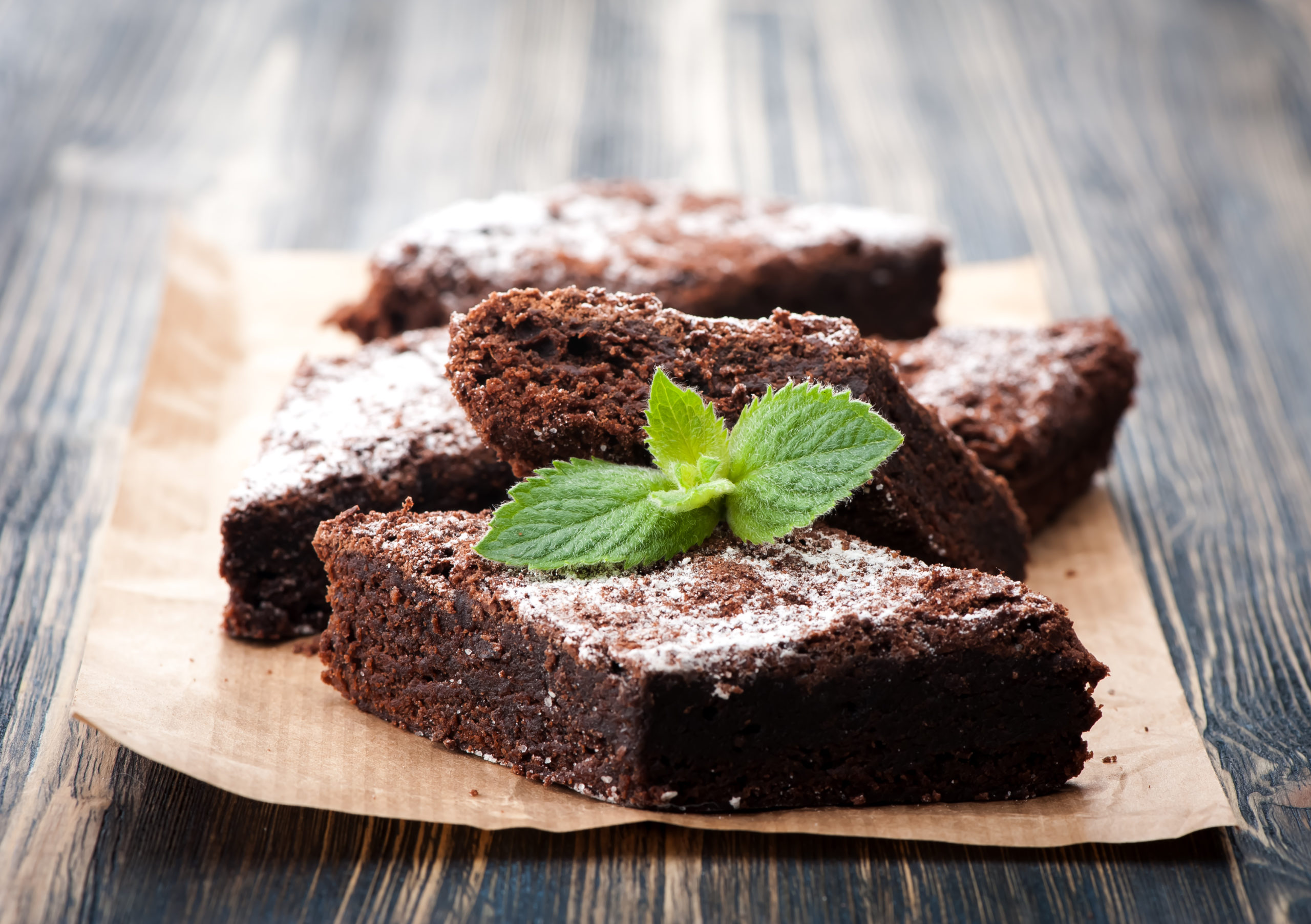 brownies on a parchment paper with a mint garnish